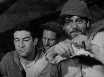 Movie still from “Stalag 17” (1953), directed by Billy Wilder – A group of men standing next to each other; Close Up shot, Low angle