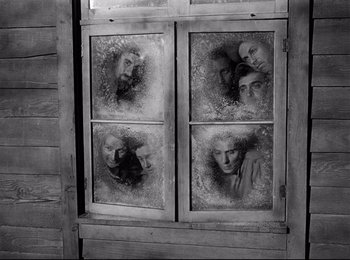 Movie still from “Stalag 17” (1953), directed by Billy Wilder – A window that has a bunch of faces in it; Medium shot, High angle