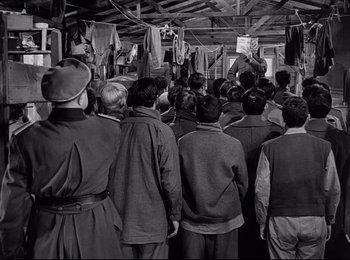 Movie still from “Stalag 17” (1953), directed by Billy Wilder – A group of people standing in front of a mirror; Wide shot, High angle