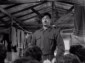 Movie still from “Stalag 17” (1953), directed by Billy Wilder – A man with a mustache standing in a room; Medium shot, Low angle