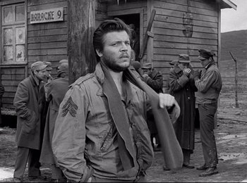 Movie still from “Stalag 17” (1953), directed by Billy Wilder – A man in a military uniform holding onto a scarf; Medium shot, Over the shoulder angle