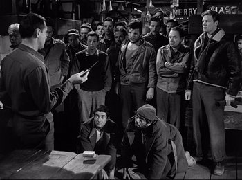 Movie still from “Stalag 17” (1953), directed by Billy Wilder – A group of men standing in a room; Medium shot, High angle