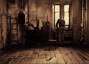 Movie still from “Stalker” (1979), directed by Andrei Tarkovsky – A man standing in front of an oven in a kitchen; Wide shot, High angle