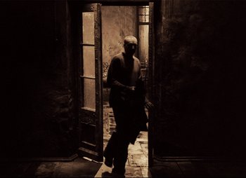 Movie still from “Stalker” (1979), directed by Andrei Tarkovsky – An old man walking through an open door; Wide shot, Low angle