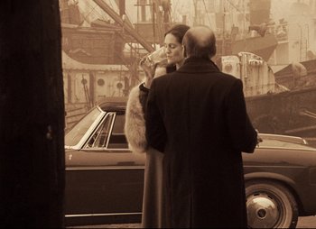 Movie still from “Stalker” (1979), directed by Andrei Tarkovsky – A man and a woman standing in front of a car; Medium shot, Over the shoulder angle
