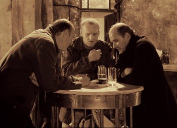Movie still from “Stalker” (1979), directed by Andrei Tarkovsky – A group of men sitting at a table with drinks; Medium shot, High angle