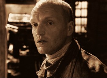 Movie still from “Stalker” (1979), directed by Andrei Tarkovsky – A man with a bald head and a goatee looking at the camera; Close Up shot, Low angle