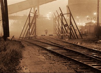 Movie still from “Stalker” (1979), directed by Andrei Tarkovsky – A man standing on the train tracks; Extreme Wide shot, High angle