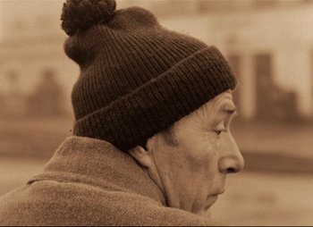 Movie still from “Stalker” (1979), directed by Andrei Tarkovsky – An older man wearing a hat and a coat; Close Up shot, Low angle