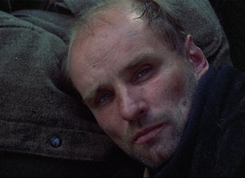 Movie still from “Stalker” (1979), directed by Andrei Tarkovsky – A person laying on the ground; Close Up shot, High angle