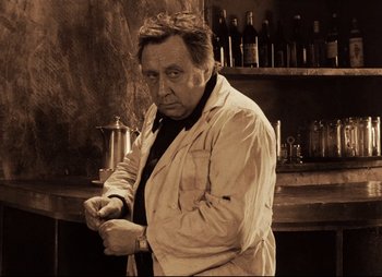 Movie still from “Stalker” (1979), directed by Andrei Tarkovsky – An older man wearing a white shirt and a black tie; Medium shot, Low angle