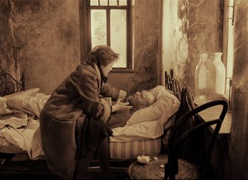 Movie still from “Stalker” (1979), directed by Andrei Tarkovsky – An older woman sitting next to a man in a bed; Medium shot, High angle