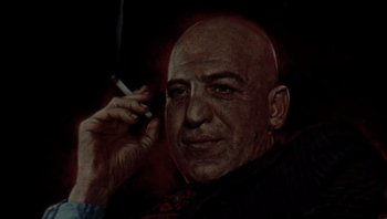 Movie still from “Star 80” (1983), directed by Bob Fosse – An older man smoking a cigarette while holding a cell phone to his ear; Close Up shot, Low angle