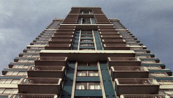 Movie still from “Star 80” (1983), directed by Bob Fosse – A tall building that has many balconies on it; Extreme Wide shot, Low angle