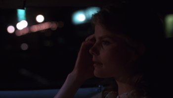 Movie still from “Star 80” (1983), directed by Bob Fosse – A woman sitting in a car at night with her hand up to her face; Close Up shot, Over the shoulder angle