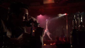 Movie still from “Star 80” (1983), directed by Bob Fosse – A man sitting at a table talking on a phone; Close Up shot, Low angle