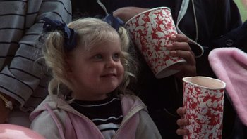 Movie still from “Star 80” (1983), directed by Bob Fosse – A little girl is holding two cups in her hands; Close Up shot, Low angle