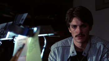 Movie still from “Star 80” (1983), directed by Bob Fosse – A man with a mustache sitting in front of a piano; Close Up shot, Over the shoulder angle