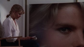 Movie still from “Star 80” (1983), directed by Bob Fosse – A woman sitting in front of a picture of a woman's face; Close Up shot, Over the shoulder angle