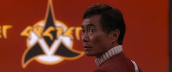 Movie still from “Star Trek VI: The Undiscovered Country” (1991), directed by Nicholas Meyer – A person wearing a red shirt; Close Up shot, Over the shoulder angle