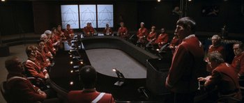 Movie still from “Star Trek VI: The Undiscovered Country” (1991), directed by Nicholas Meyer – A group of men in red jackets sitting around a table; Extreme Wide shot, High angle