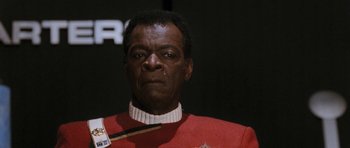 Movie still from “Star Trek VI: The Undiscovered Country” (1991), directed by Nicholas Meyer – A man in a red and white uniform holding a stick; Close Up shot, Low angle