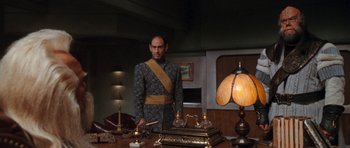 Movie still from “Star Trek VI: The Undiscovered Country” (1991), directed by Nicholas Meyer – A man standing in front of a table with a lamp; Medium shot, Low angle