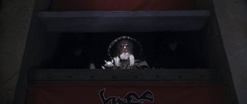 Movie still from “Star Trek VI: The Undiscovered Country” (1991), directed by Nicholas Meyer – A man with long hair and a beard is looking out of a window; Wide shot, Low angle