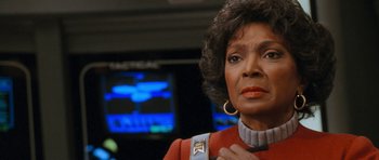 Movie still from “Star Trek VI: The Undiscovered Country” (1991), directed by Nicholas Meyer – An older woman in a red jacket holding a blue bag; Close Up shot, Low angle