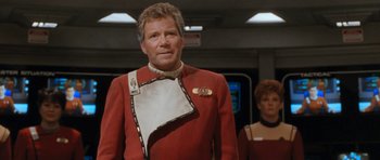 Movie still from “Star Trek VI: The Undiscovered Country” (1991), directed by Nicholas Meyer – A man in a red and white uniform standing next to a woman; Medium shot, Over the shoulder angle