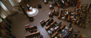 Movie still from “Star Trek VI: The Undiscovered Country” (1991), directed by Nicholas Meyer – People are sitting in a room with benches and tables; Extreme Wide shot, Overhead angle