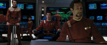 Movie still from “Star Trek VI: The Undiscovered Country” (1991), directed by Nicholas Meyer – A group of men sitting on top of a blue chair; Medium shot, Over the shoulder angle