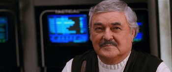 Movie still from “Star Trek VI: The Undiscovered Country” (1991), directed by Nicholas Meyer – An older man in front of a television screen; Close Up shot, Over the shoulder angle