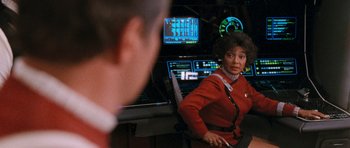 Movie still from “Star Trek VI: The Undiscovered Country” (1991), directed by Nicholas Meyer – A woman in a red jacket standing in front of a man; Medium shot, Over the shoulder angle