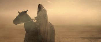 Movie still from “Star Trek V: The Final Frontier” (1989), directed by William Shatner – A person riding a horse in the middle of the desert; Wide shot, Low angle