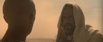 Movie still from “Star Trek V: The Final Frontier” (1989), directed by William Shatner – A man with a beard is standing next to another man with a beard; Close Up shot, Over the shoulder angle