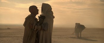 Movie still from “Star Trek V: The Final Frontier” (1989), directed by William Shatner – A couple of people standing next to each other on a beach; Wide shot, Low angle