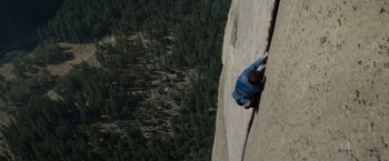 Movie still from “Star Trek V: The Final Frontier” (1989), directed by William Shatner – A man climbing a rock wall on the side of a mountain; Extreme Wide shot, Overhead angle