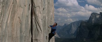 Movie still from “Star Trek V: The Final Frontier” (1989), directed by William Shatner – A man climbing a rock wall on top of a mountain; Wide shot, Low angle