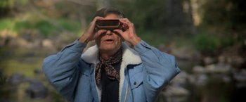 Movie still from “Star Trek V: The Final Frontier” (1989), directed by William Shatner – An older man looking through a pair of binoculars; Close Up shot, Over the shoulder angle