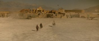 Movie still from “Star Trek V: The Final Frontier” (1989), directed by William Shatner – Two people walking in the sand in front of a building; Extreme Wide shot, High angle
