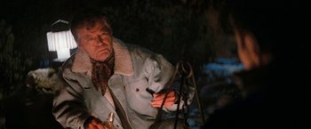Movie still from “Star Trek V: The Final Frontier” (1989), directed by William Shatner – An older man sitting on a chair in the dark; Medium shot, Over the shoulder angle