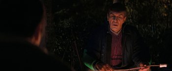 Movie still from “Star Trek V: The Final Frontier” (1989), directed by William Shatner – An older man is sitting in the dark outside; Close Up shot, Over the shoulder angle