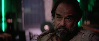 Movie still from “Star Trek V: The Final Frontier” (1989), directed by William Shatner – A person with a beard looking at the camera; Close Up shot, Over the shoulder angle