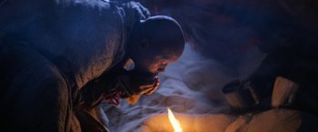 Movie still from “Star Trek V: The Final Frontier” (1989), directed by William Shatner – A man kneeling down in front of a lit candle; Extreme Close Up shot, Low angle