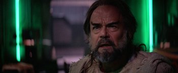 Movie still from “Star Trek V: The Final Frontier” (1989), directed by William Shatner – A man with long hair and a beard stares at the camera; Close Up shot, Over the shoulder angle