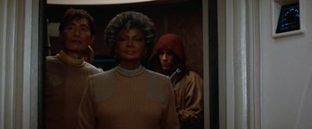 Movie still from “Star Trek V: The Final Frontier” (1989), directed by William Shatner – A group of people standing next to each other in a room; Medium shot, Over the shoulder angle