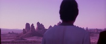 Movie still from “Star Trek V: The Final Frontier” (1989), directed by William Shatner – A man standing in front of a mountain range; Wide shot, Over the shoulder angle