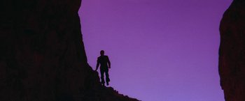 Movie still from “Star Trek V: The Final Frontier” (1989), directed by William Shatner – A man is climbing up a steep hill; Extreme Wide shot, Low angle