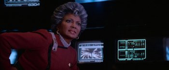 Movie still from “Star Trek V: The Final Frontier” (1989), directed by William Shatner – A woman in a star trek costume looking into the camera; Close Up shot, Over the shoulder angle